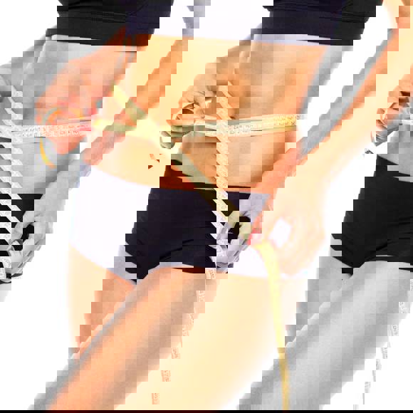 Woman measuring her slim waist after body contouring treatment