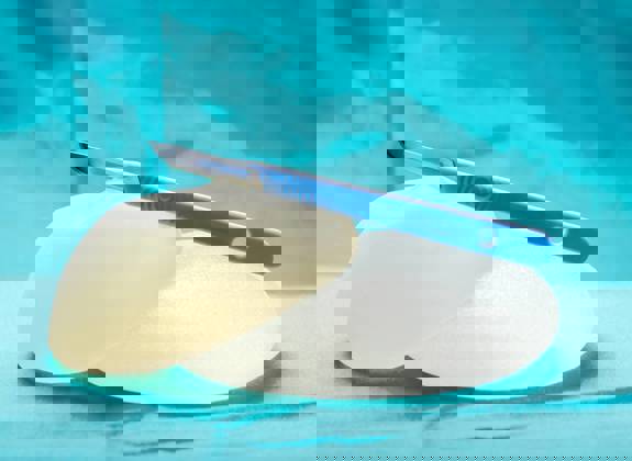 Silicone breast implants with a surgical scalpel, representing breast reconstruction surgery