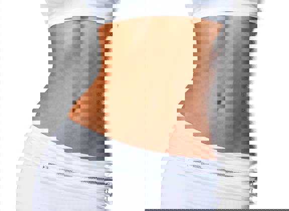 Woman with flat abdomen and smooth skin after lipolysis treatment