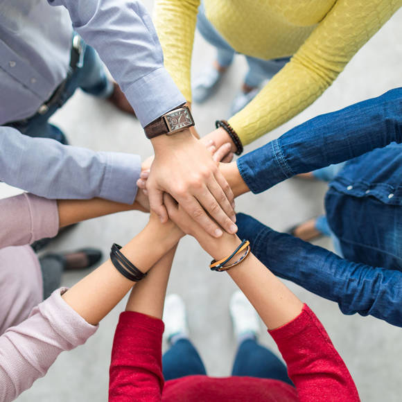 Team members joining hands in unity