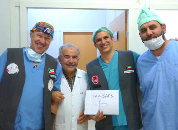Volunteer surgeons posing with local medical staff during a humanitarian mission