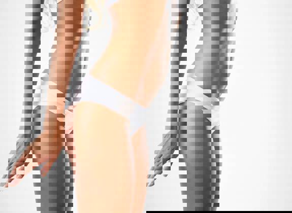 Female body contour after liposuction and skin tightening showing flat abdomen and defined waistline