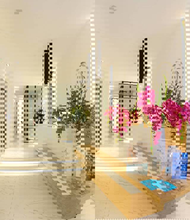 Bright reception area with modern decor and orchid flowers at Opsis Clinical