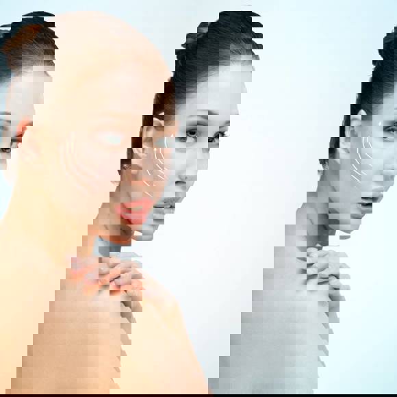 Portrait of a woman with clear skin and gentle upward contour lines on her cheek